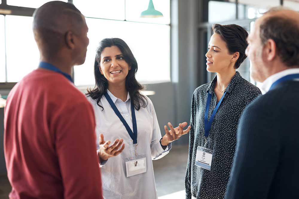 A diverse group of people discussing ideas together in a collaborative office environment.