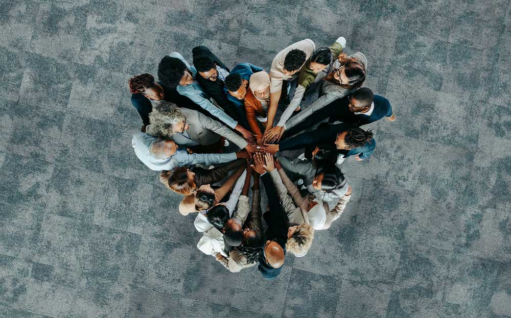 People arranged in a heart shape, showcasing their commitment to human rights and community support.